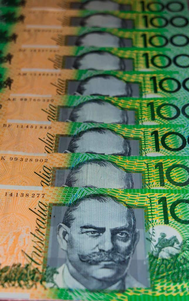Vertical close-up of stacked Australian 100-dollar banknotes showcasing currency details.